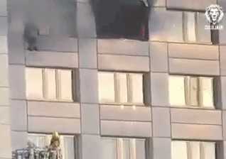 Momentul dramatic în care o femeie sare de la etajul 11, în braţele pompierului, pentru a scăpa de incendiu